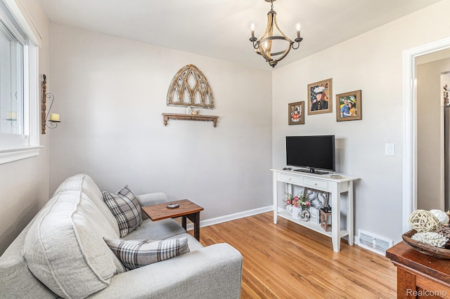 1820 W Longmeadow Rd, Trenton, MI 48183 - living room featuring light wood-style flooring, a chandelier, and healthy amount of natural light
