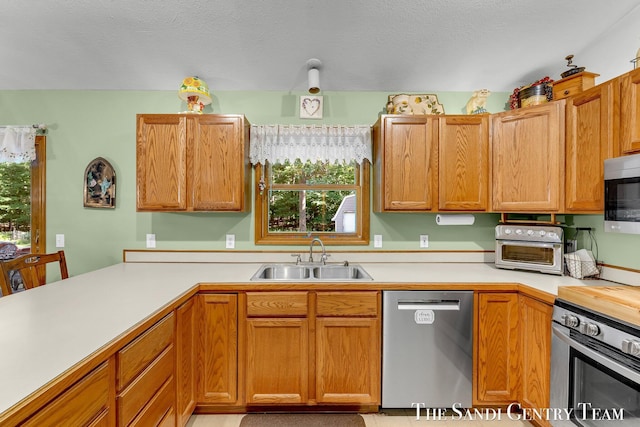 15071 Steves Dr, Grand Haven, MI 49417 - kitchen with appliances with stainless steel finishes, light countertops, healthy amount of natural light, and a peninsula