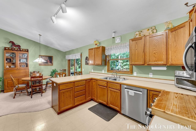 15071 Steves Dr, Grand Haven, MI 49417 - kitchen featuring dishwasher, a peninsula, vaulted ceiling, light countertops, and pendant lighting