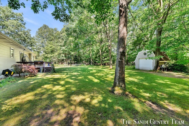15071 Steves Dr, Grand Haven, MI 49417 - view of green lawn with a storage unit, a wooden deck, and a garage