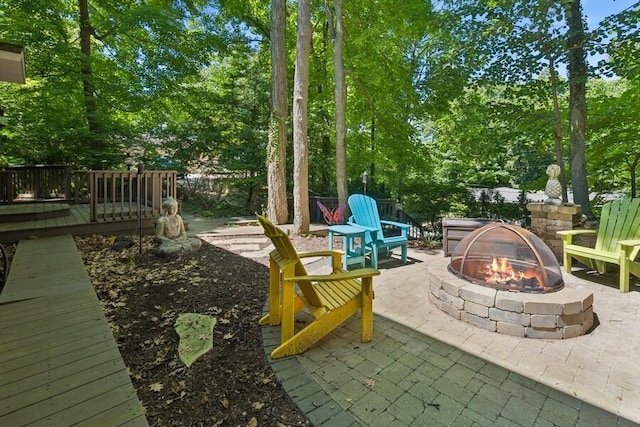 613 Indian Trl, Sawyer, MI 49125 - view of patio featuring an outdoor fire pit, a deck, and view of wooded area