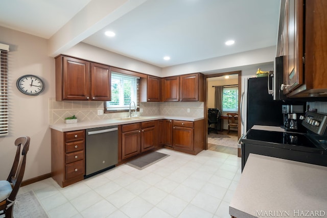2934 Meadowbrook Dr SE, Grand Rapids, MI 49546 - kitchen with stainless steel dishwasher, black electric range, light countertops, tasteful backsplash, and plenty of natural light