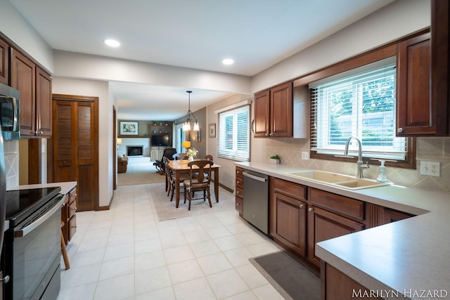 2934 Meadowbrook Dr SE, Grand Rapids, MI 49546 - kitchen with stainless steel appliances, decorative backsplash, light countertops, hanging light fixtures, and recessed lighting