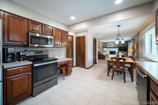 2934 Meadowbrook Dr SE, Grand Rapids, MI 49546 - kitchen featuring appliances with stainless steel finishes, open floor plan, light countertops, decorative backsplash, and recessed lighting