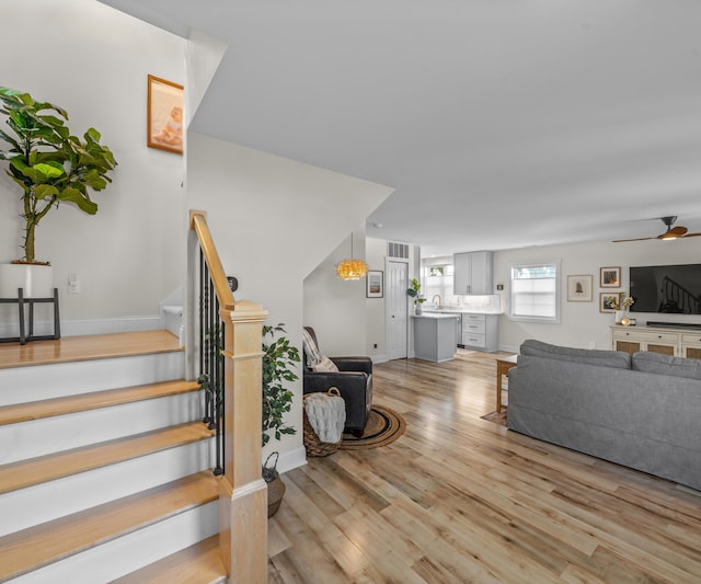 820 Barton Dr, Ann Arbor, MI 48105 - living area with light wood-style flooring, ceiling fan, and stairway