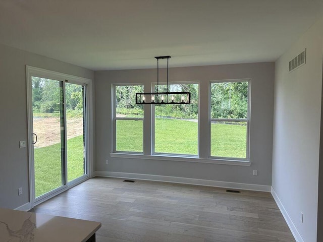 3490 Mare Cir, Wixom, MI 48393 - unfurnished dining area featuring wood finished floors and a chandelier