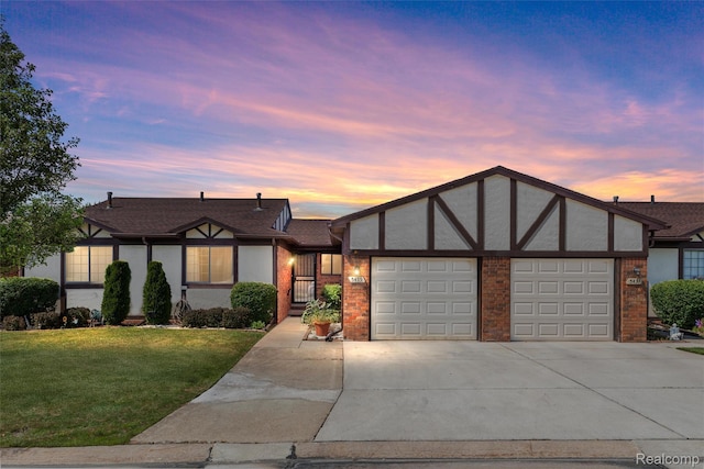 5419 Duke Ct, Warren, MI 48091 - english style home with an attached garage, driveway, stucco siding, a front lawn, and brick siding