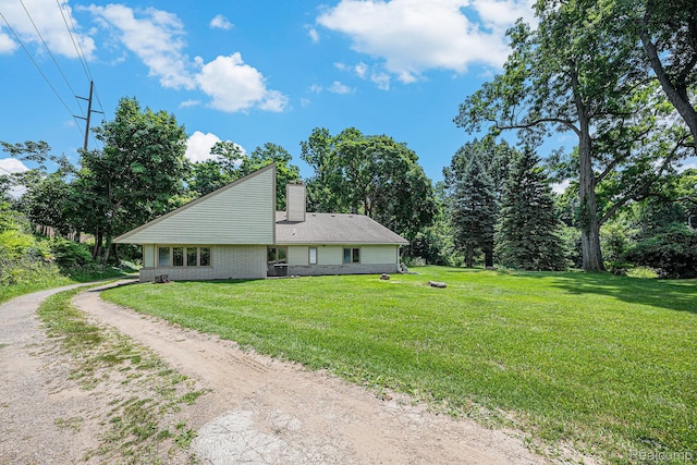 36680 Howard Rd, Farmington, MI 48331 - view of side of home featuring a chimney, dirt driveway, and a lawn