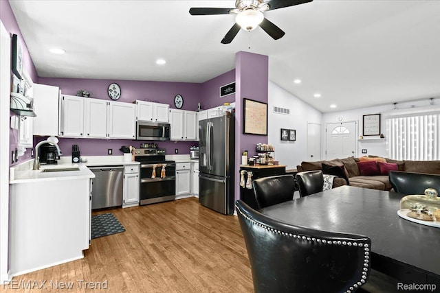 9125 Mandon Rd, White Lake, MI 48386 - kitchen with stainless steel appliances, light countertops, vaulted ceiling, light wood-type flooring, and ceiling fan