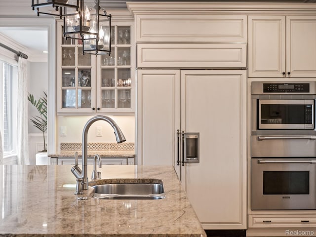 1200 Shipman Blvd, Birmingham, MI 48009 - kitchen featuring built in appliances, cream cabinets, a chandelier, light stone countertops, and crown molding