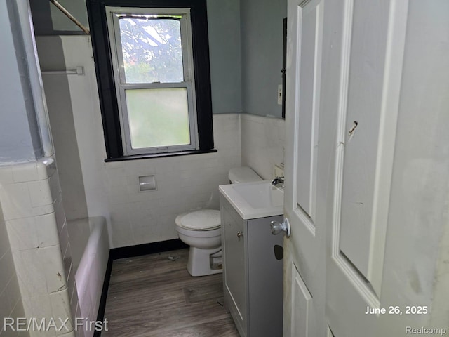 9379 Manor St, Detroit, MI 48204 - full bathroom featuring vanity, wood finished floors, tile walls, and a wainscoted wall