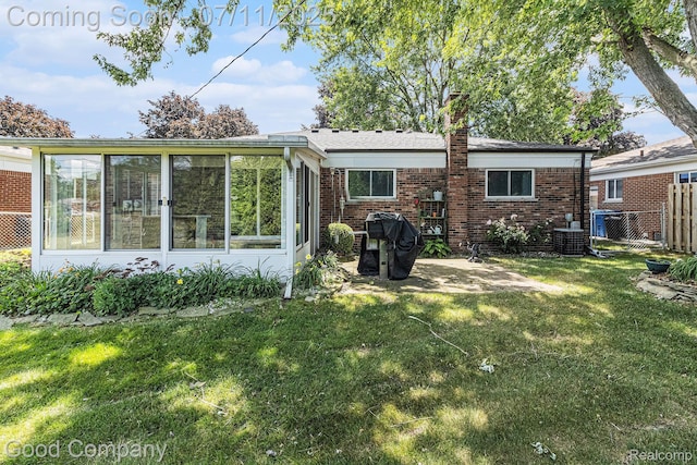 3847 Dwight Dr, Warren, MI 48092 - rear view of house featuring a sunroom, brick siding, a chimney, and a patio area