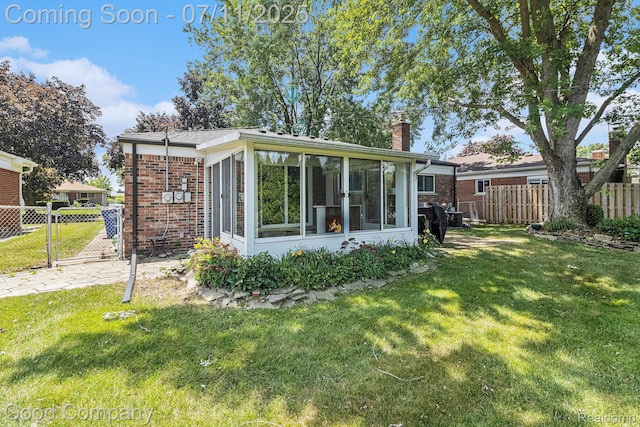 3847 Dwight Dr, Warren, MI 48092 - back of house featuring a chimney, a sunroom, brick siding, and a gate