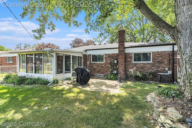3847 Dwight Dr, Warren, MI 48092 - rear view of house featuring a chimney, brick siding, a patio, a sunroom, and a lawn