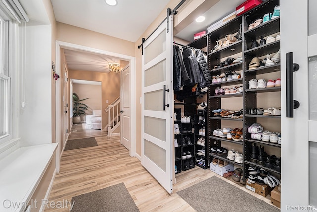 14128 Ellen Dr, Dearborn Heights, MI 48154 - walk in closet with a barn door, wood finished floors, and a chandelier