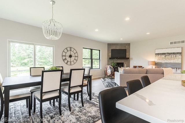 3184 Roma Ct, Wixom, MI 48393 - dining space featuring a chandelier, recessed lighting, a fireplace, and wood finished floors