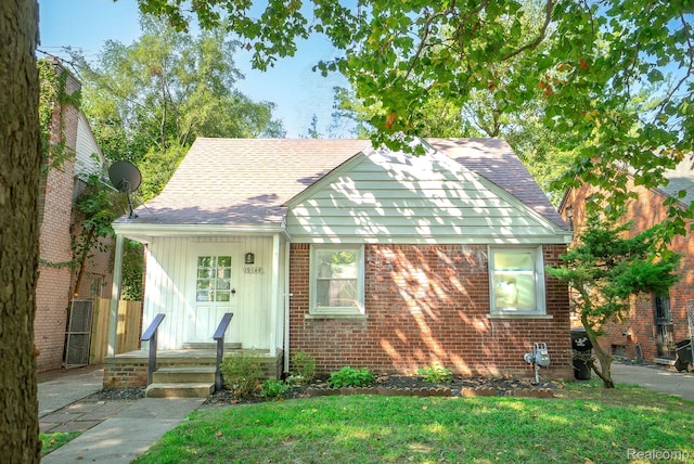 19145 Strasburg St, Detroit, MI 48205 - view of front of house with a front lawn, brick siding, and roof with shingles