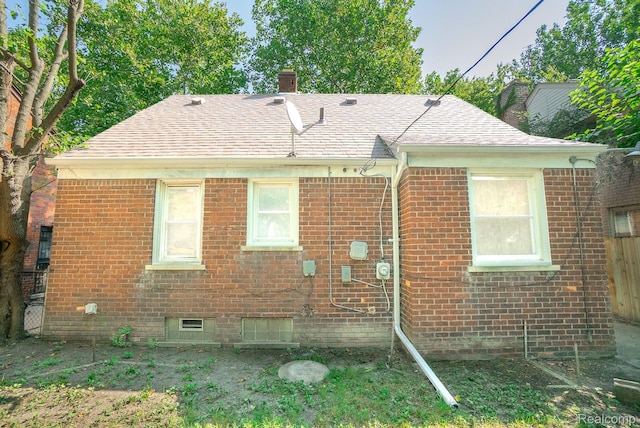 19145 Strasburg St, Detroit, MI 48205 - rear view of property with a chimney, brick siding, roof with shingles, and crawl space
