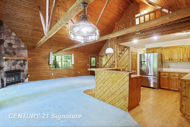 13715 Baldwin Rd, Saginaw, MI 48616 - kitchen featuring stainless steel refrigerator with ice dispenser, open floor plan, a wooden ceiling with exposed beams, wood walls, and a fireplace