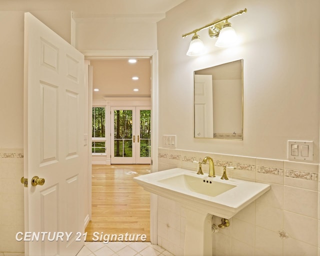 13715 Baldwin Rd, Saginaw, MI 48616 - bathroom featuring tile walls, a wainscoted wall, tile patterned flooring, and french doors
