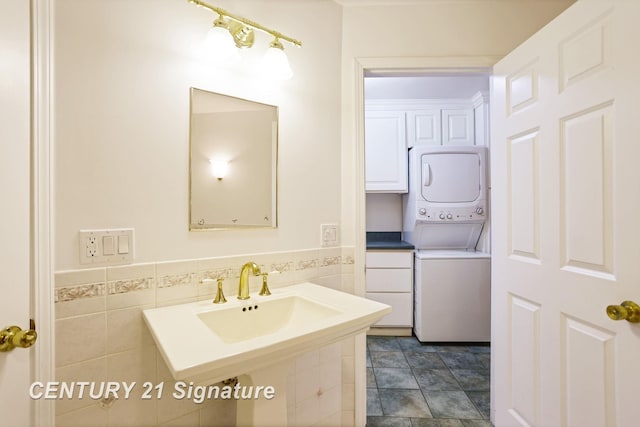13715 Baldwin Rd, Saginaw, MI 48616 - bathroom featuring stacked washing machine and dryer, tile walls, and a wainscoted wall