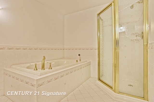 13715 Baldwin Rd, Saginaw, MI 48616 - full bathroom featuring a garden tub, a stall shower, tile patterned floors, wainscoting, and tile walls