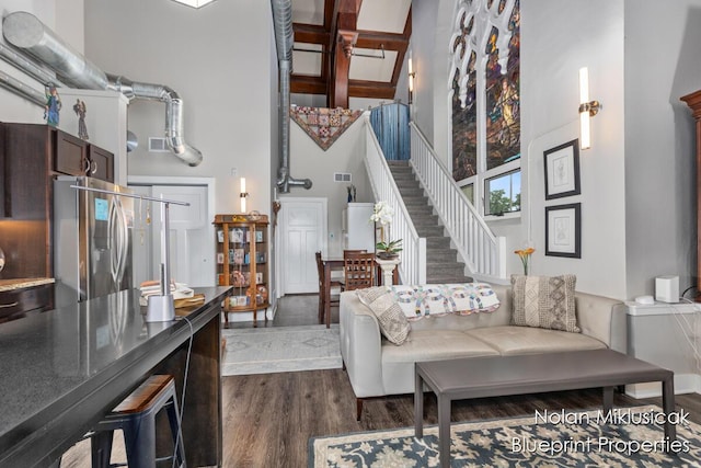 253 Prospect Ave NE Unit 309, Grand Rapids, MI 49503 - living area featuring a towering ceiling, dark wood-style flooring, stairs, and beam ceiling