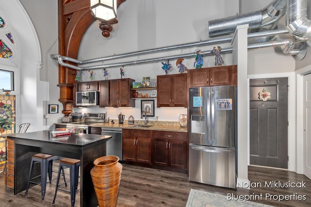 253 Prospect Ave NE Unit 309, Grand Rapids, MI 49503 - kitchen featuring stainless steel appliances, dark wood-type flooring, open shelves, lofted ceiling, and dark brown cabinetry