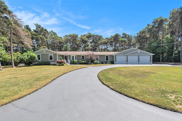 5920 Iris Rd, Ludington, MI 49431 - single story home featuring a front yard, driveway, and view of wooded area
