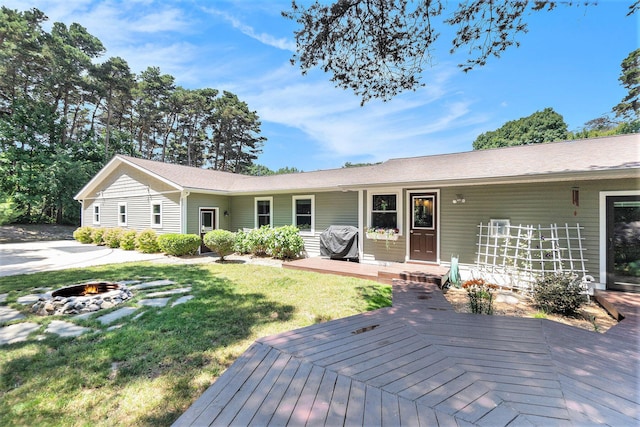 5920 Iris Rd, Ludington, MI 49431 - view of front of house featuring a fire pit, a wooden deck, and a front yard