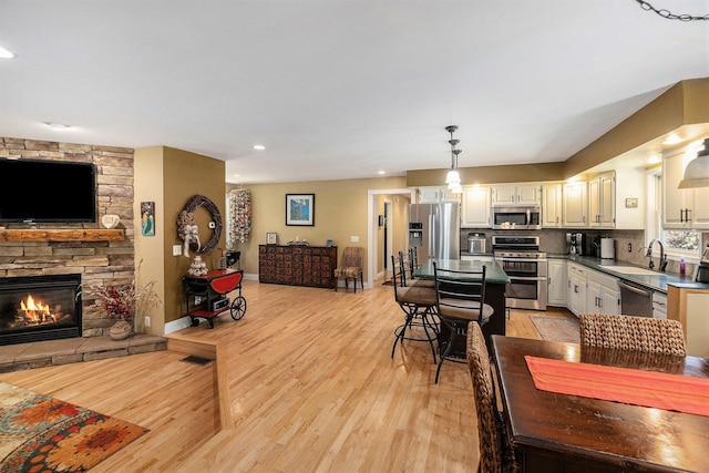 5920 Iris Rd, Ludington, MI 49431 - dining area featuring a stone fireplace, light wood-style flooring, and recessed lighting