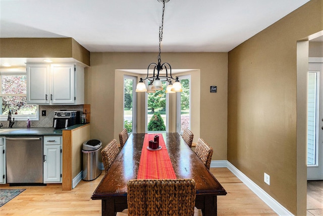 5920 Iris Rd, Ludington, MI 49431 - dining room featuring light wood-style flooring and a chandelier