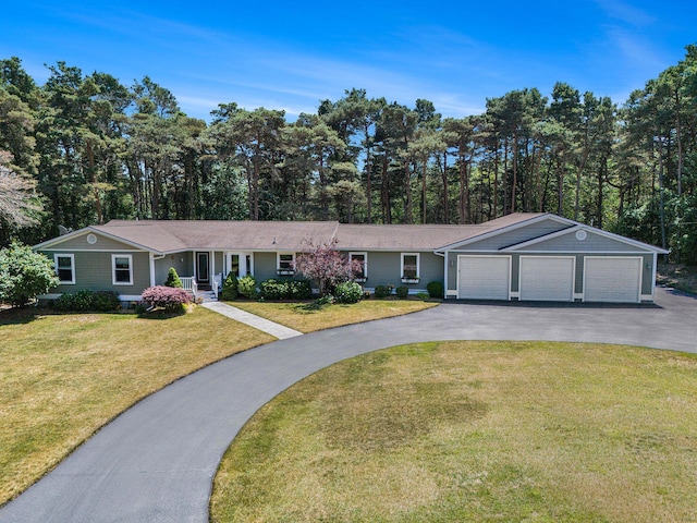 5920 Iris Rd, Ludington, MI 49431 - ranch-style house with a front yard, driveway, a garage, an outbuilding, and a porch