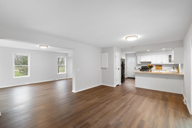 10833 W O Ave, Michigan, MI 49071 - kitchen featuring open floor plan, a peninsula, freestanding refrigerator, stove, and white cabinets