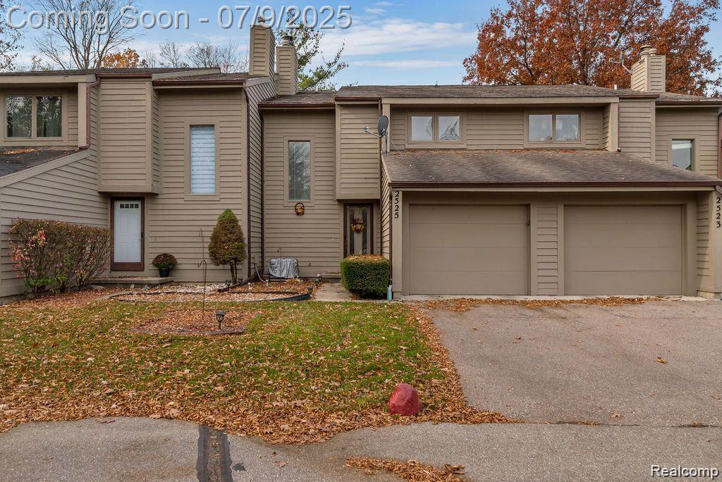 2525 White Oak Pl, Grand Blanc, MI 48532 - view of front of property with a chimney, asphalt driveway, and a garage