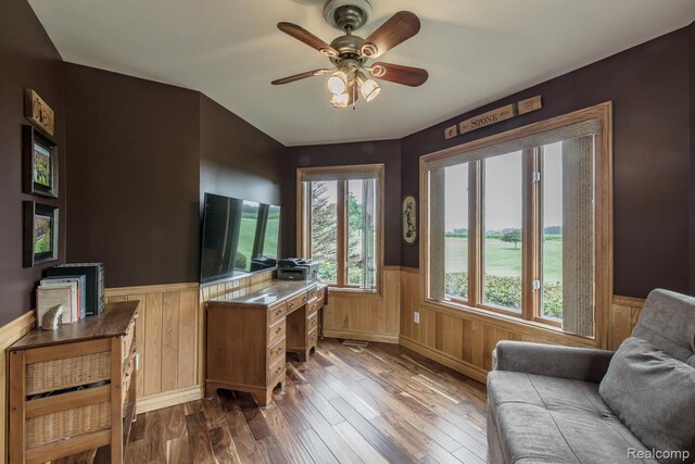 2086 Haines Rd, Lapeer, MI 48446 - home office with a wainscoted wall, dark wood-style floors, and ceiling fan