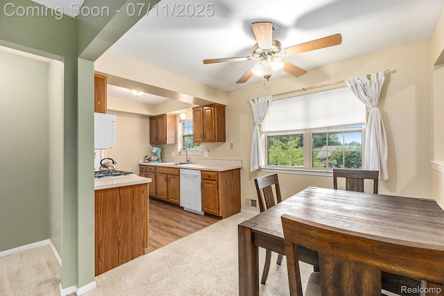 41455 Clinton Grove Dr, Clinton Township, MI 48038 - kitchen featuring white dishwasher, brown cabinets, ceiling fan, light countertops, and light carpet