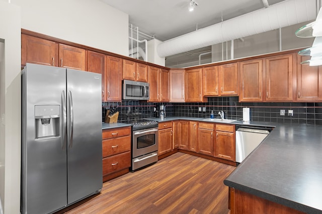 125 S Kalamazoo Mall Unit 603, Kalamazoo, MI 49007 - kitchen with stainless steel appliances, dark countertops, brown cabinetry, and decorative backsplash