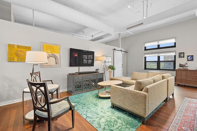 125 S Kalamazoo Mall Unit 603, Kalamazoo, MI 49007 - living room featuring a barn door, wood finished floors, track lighting, and a towering ceiling