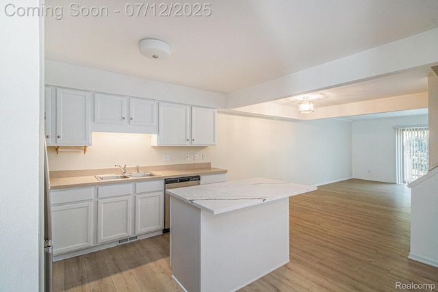 7924 Meadow Dr, Waterford, MI 48329 - kitchen featuring stainless steel dishwasher, light countertops, white cabinetry, and light wood finished floors
