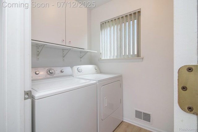 7924 Meadow Dr, Waterford, MI 48329 - washroom featuring cabinet space, washing machine and dryer, and light wood-type flooring