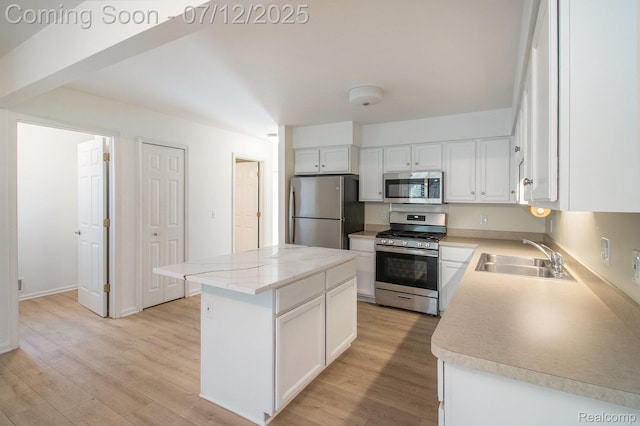 7924 Meadow Dr, Waterford, MI 48329 - kitchen featuring stainless steel appliances, a center island, light wood-type flooring, white cabinets, and light countertops