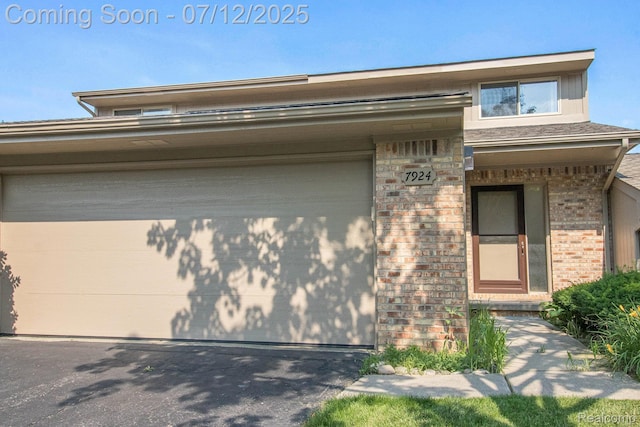 7924 Meadow Dr, Waterford, MI 48329 - view of front facade featuring a garage, brick siding, and asphalt driveway