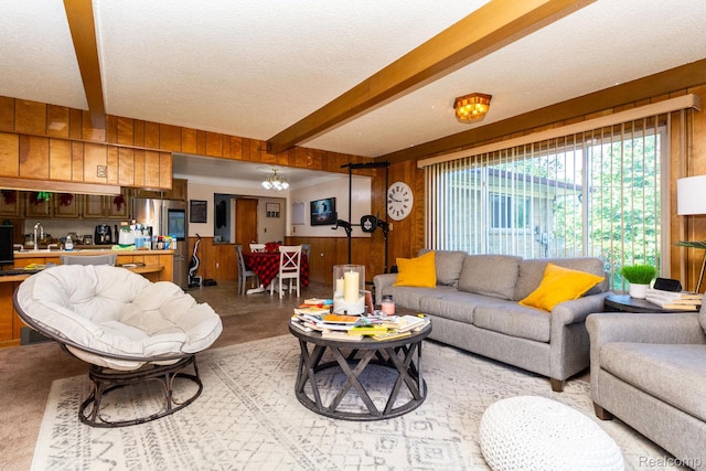 8345 E 14 Mile Rd, Sterling Heights, MI 48312 - living area featuring wood walls, beamed ceiling, a textured ceiling, and a chandelier