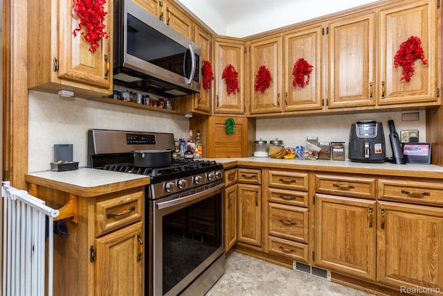 8345 E 14 Mile Rd, Sterling Heights, MI 48312 - kitchen with stainless steel appliances, light countertops, and brown cabinets