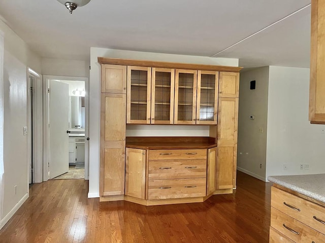 3304 Wanda Ave, Muskegon, MI 49442 - kitchen with dark wood finished floors, glass insert cabinets, and light brown cabinetry