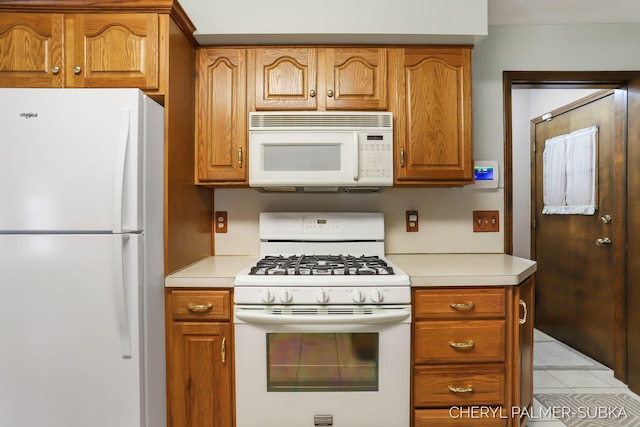 1838 Kings Ct, Muskegon, MI 49445 - kitchen featuring white appliances, light countertops, brown cabinets, and light tile patterned floors