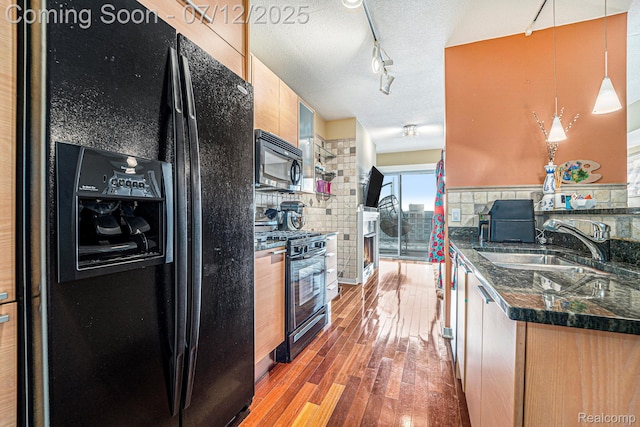 432 S Washington Ave Unit 802, Royal Oak, MI 48067 - kitchen with black appliances, wood-type flooring, rail lighting, dark stone counters, and hanging light fixtures