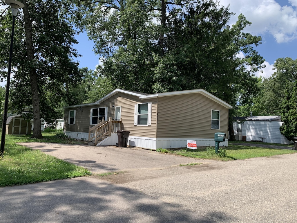 25614 Marshall Dr, Mattawan, MI 49071 - manufactured / mobile home featuring a storage shed, driveway, and view of scattered trees