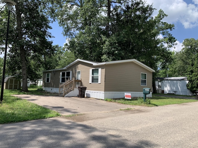 25614 Marshall Dr, Mattawan, MI 49071 - manufactured / mobile home featuring a storage shed, driveway, and view of scattered trees